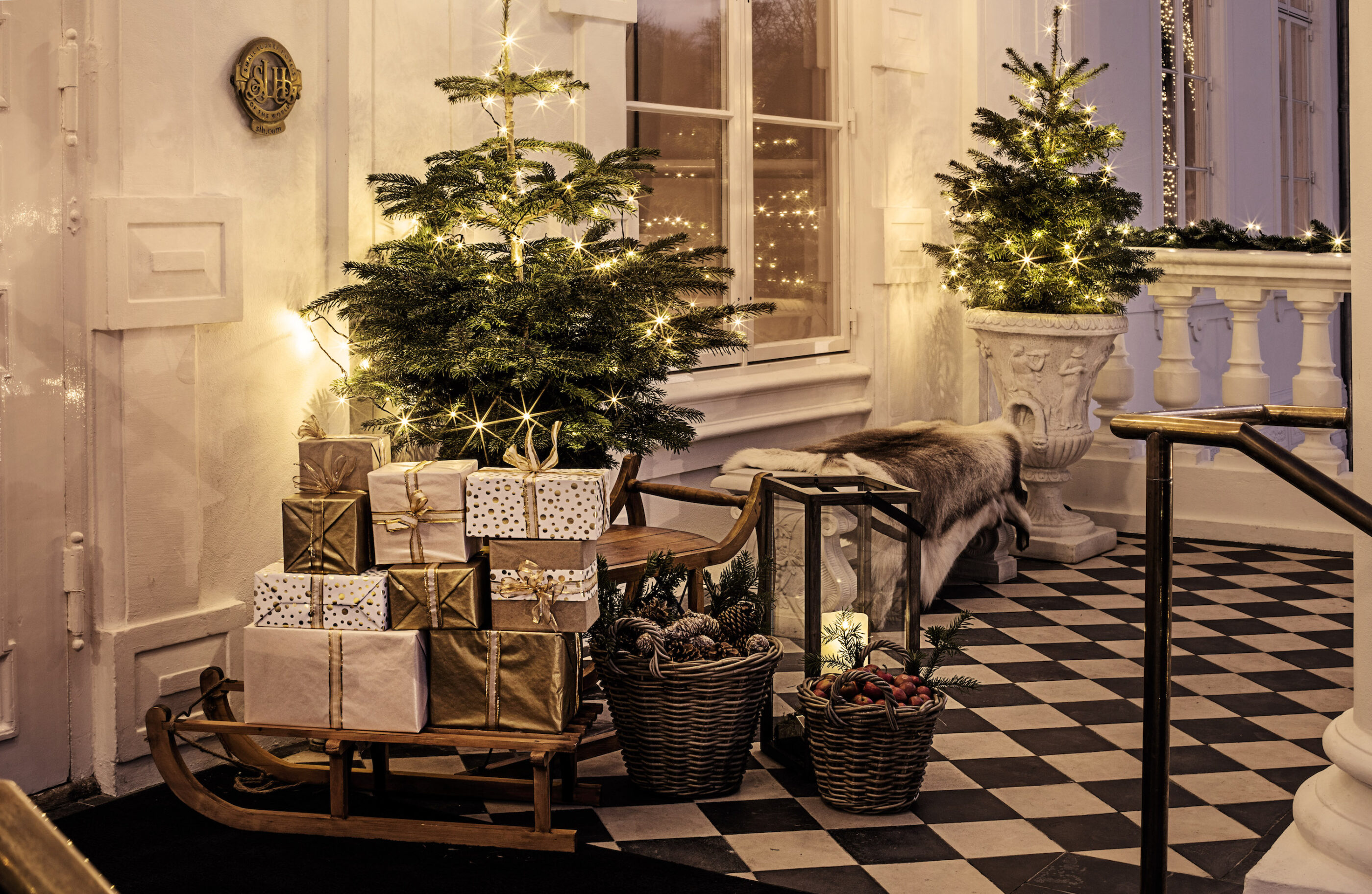 Ved indgangen af hotellet nær trapperne ligger en masse gaver i luksuriøst indpakning belyst af flot juledekoration